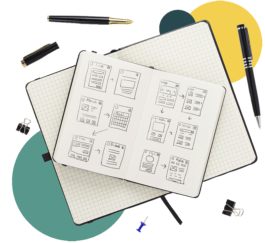 Wireframes in a note book with several pens and binder clips around the book.